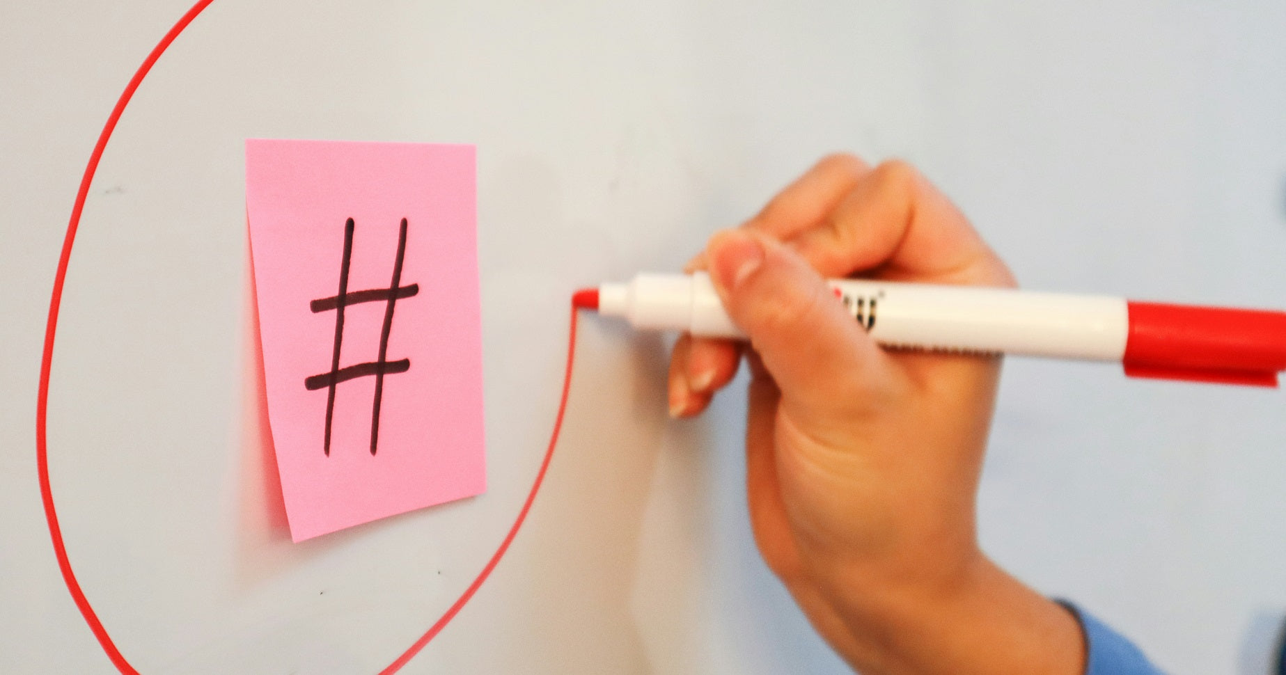 Das Foto zeigt eine Hand, die einen Hashtag auf ein Whiteboard zeichnet. Welche TikTok Hashtags du für dein Business nutzen solltest, zeigen wir dir in diesem Beitrag.