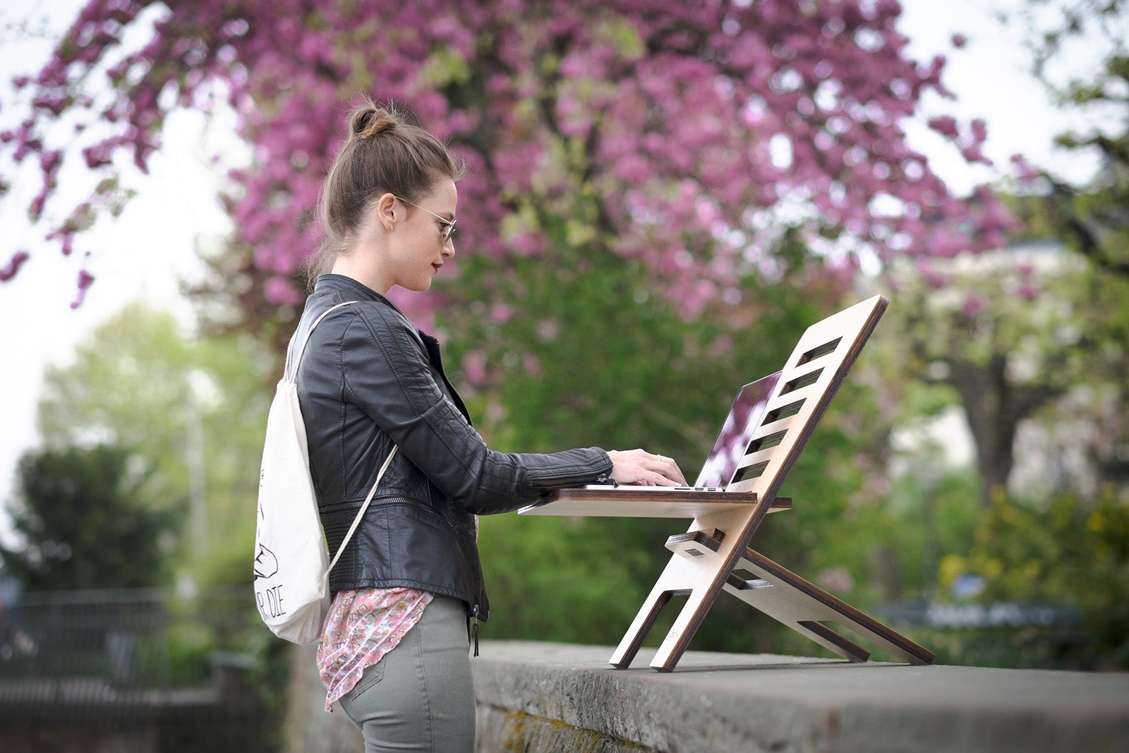 Eine Person nutzt draußen einen flexiblen Laptopstand, was ein Trendprodukt 2024 ist