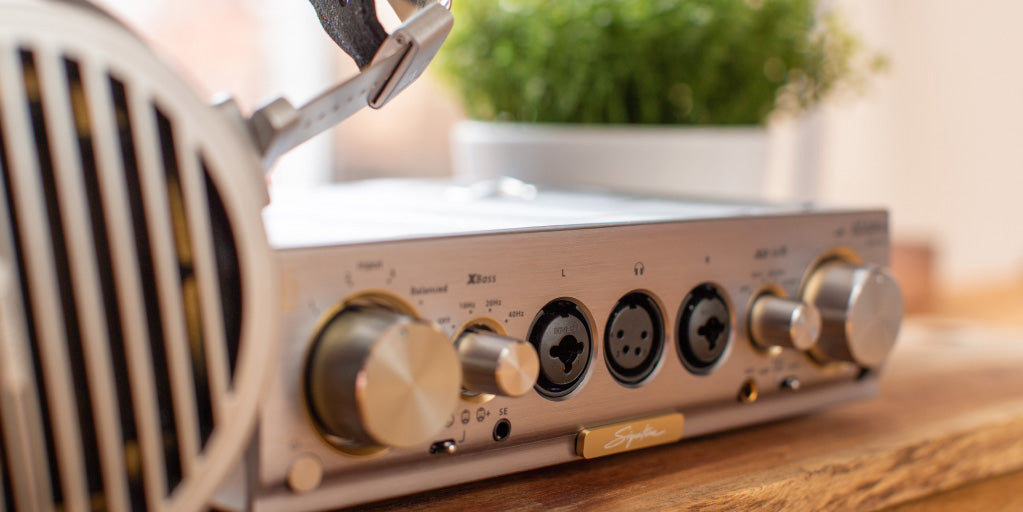 iFi Audio Pro iCAN Signature, in close detail on desk shown with headphones | Headphones.com