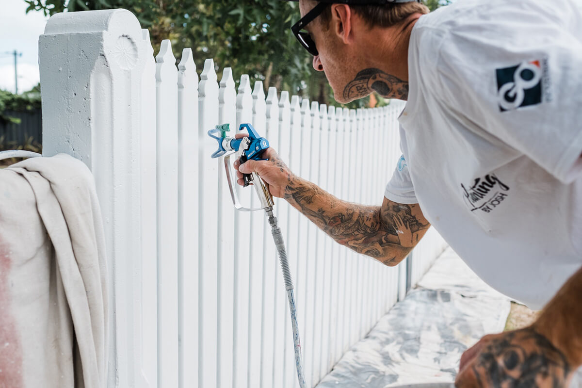 Painting by Josh spraying fence