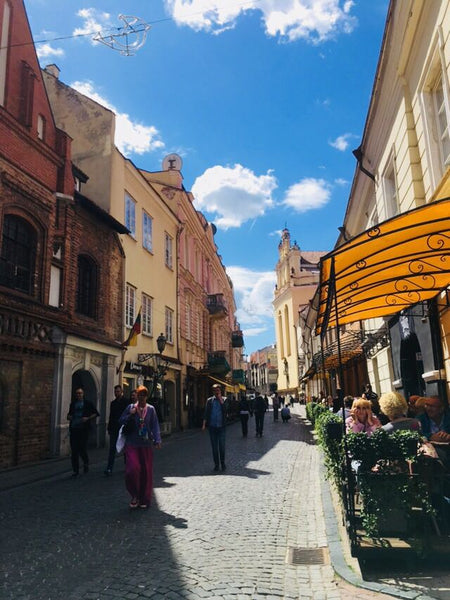 Indre strolling the quaint old town streets of Vilnius in Lithuania wearing linen pants