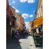 Indre walking downt he street in Vilnius, Lithuania, wearing fuchsia linen pants