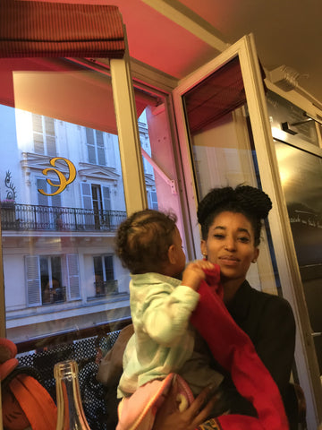 una niña pequeña en París, siendo una mano llena con su tía en el Café Constant. ShoptheKei.com