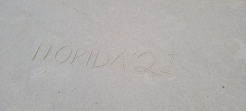 "Florida '21" written in the sand