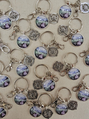 all key chains finished with compass charm added all laid out on canvas background