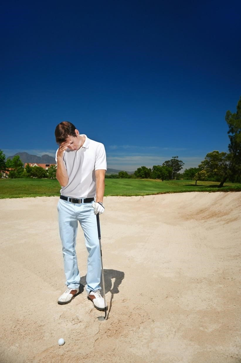 sad golfer standing in the bunker