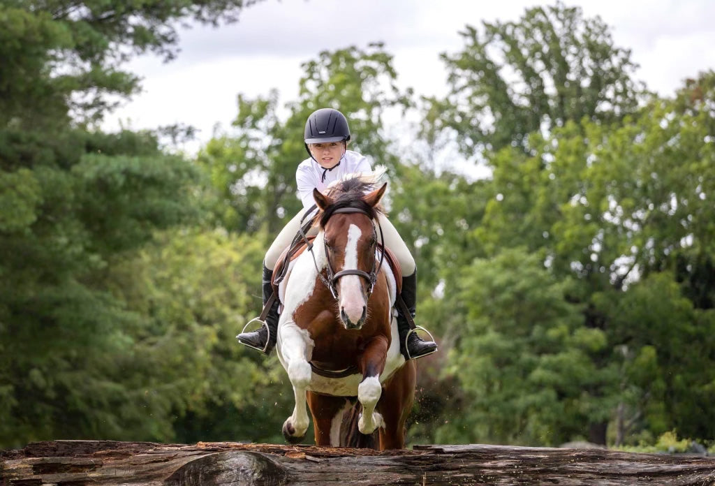 Arianna Johnson jumping over a log