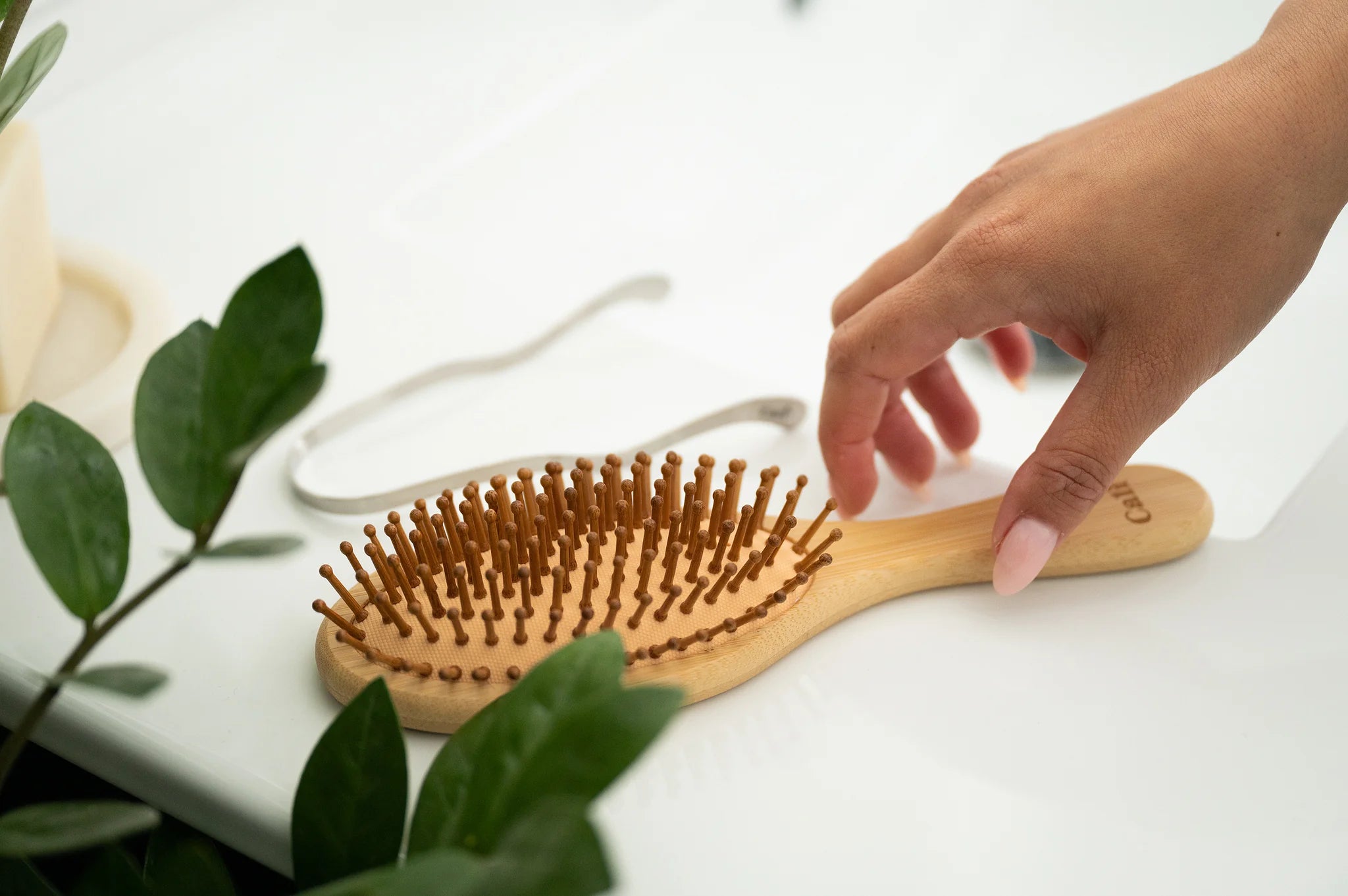 CaliWoods Bamboo Hairbrush with hand reaching handle
