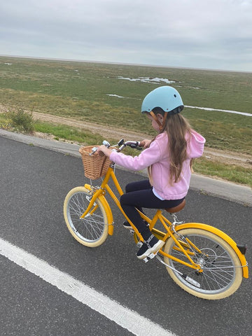Child riding a yellow Bobbin 20 inch bike