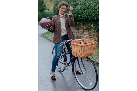 A woman in a blazer sitting on a vintage bike
