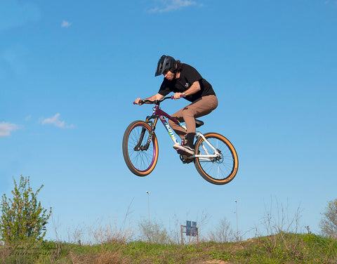 BMX rider executing a stylish mid-air stunt skillfully and precisely.]