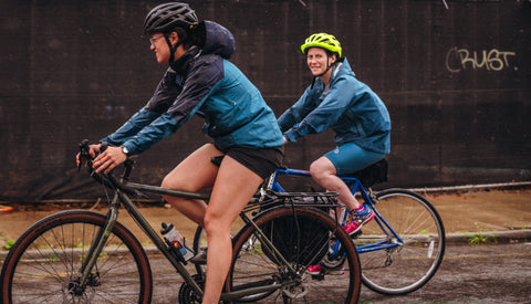 Two women riding bicycles on the street.