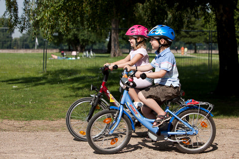 Two kids cycling in the park