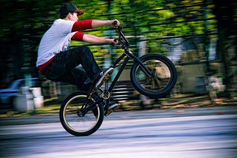 Young rider performing the ‘fakie riding’ BMX trick.