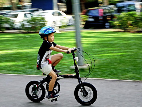 Ein Kind auf seinem Fahrrad mit Stützrädern