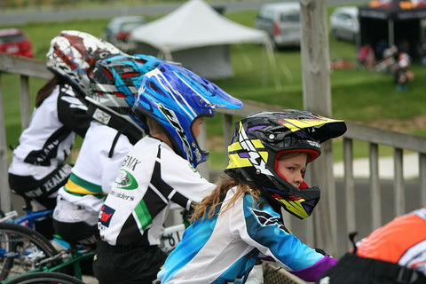 Young BMX riders eagerly lined up, poised and ready for action, awaiting the signal to start the race.
