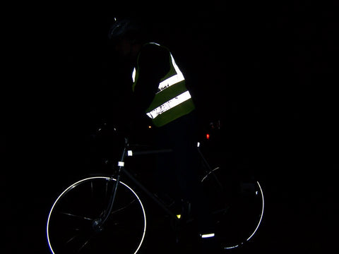 Ein Radfahrer trägt beim nächtlichen Radfahren reflektierende Kleidung