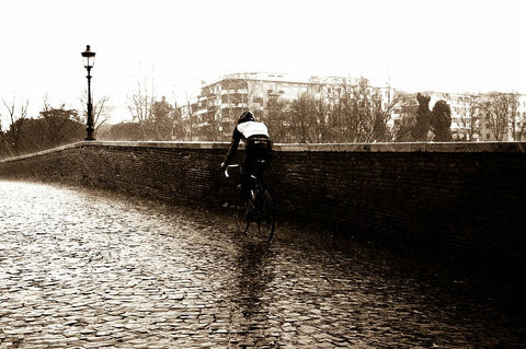 A cyclist pedalling through the city in the rain