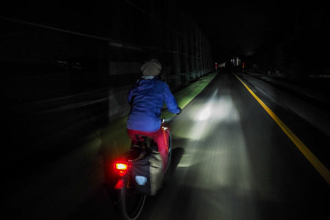 A cyclist cycling at night on the road in Yuni, Hokkaido, Japan.