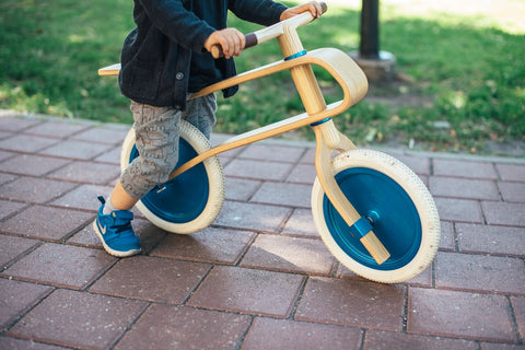 Enfant sur un vélo d'équilibre en bois