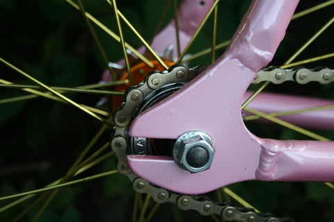 Nahaufnahme einer Fahrradkette in einem rosa Fahrrad