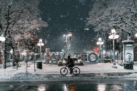 Eine Person auf ihrem Fahrrad in einer Winternacht