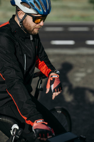 Man in black windproof jacket riding bicycle.