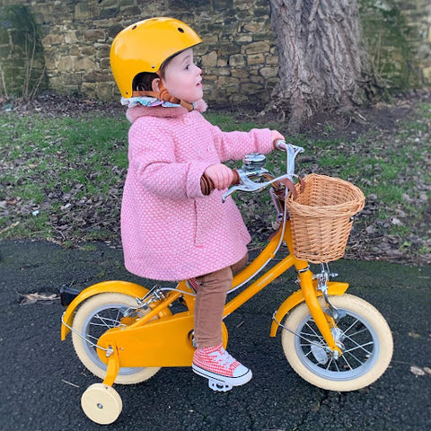Enfant sur un vélo à bobine jaune