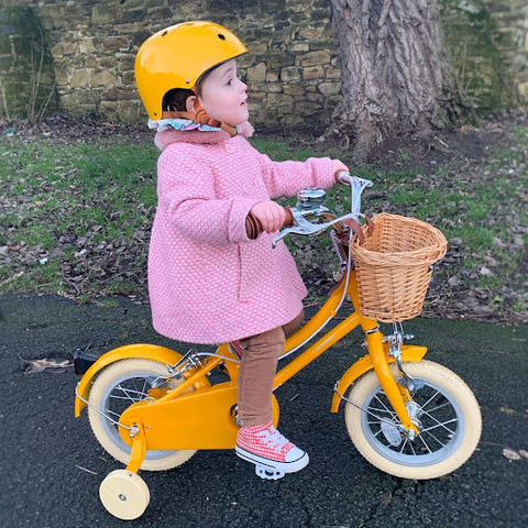 Child on a yellow bobbin bike