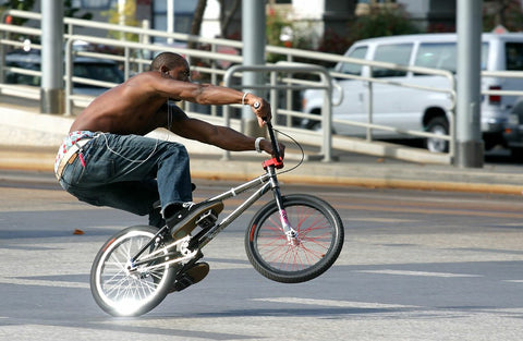 A BMX rider captured mid-action, poised to execute a daring stunt.