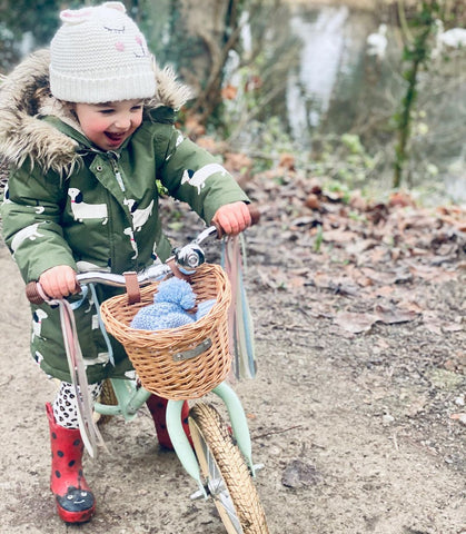 enfant enveloppé sur un vélo de canette en hiver