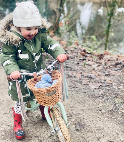 wrapped up kid on a bobbin bike in winter