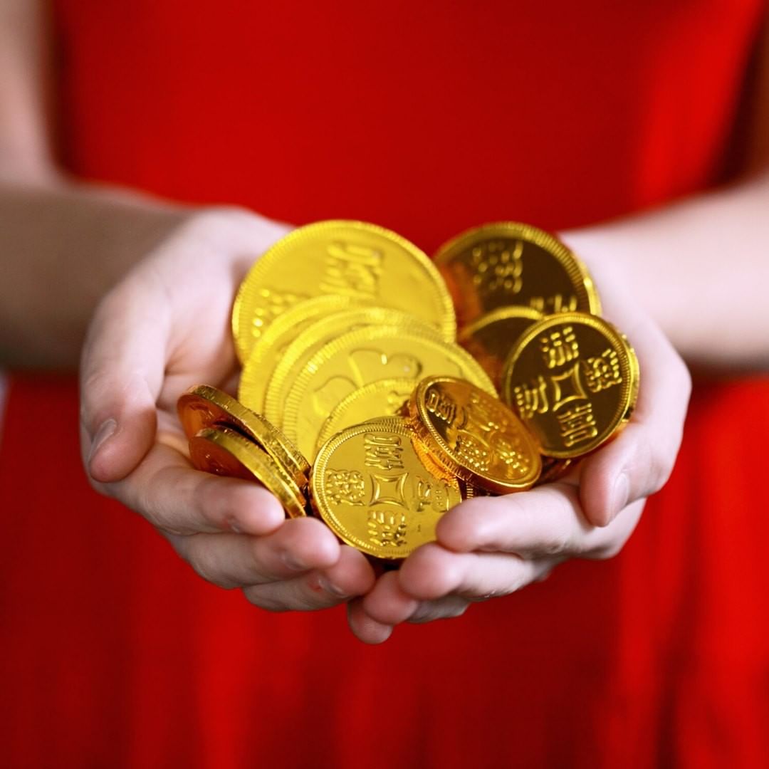 Pile of gold chinese coins in hands
