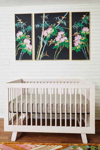 The babyletto Hudson 3-in-1 Crib in Washed Natural in Annette Vartanian's Vintage Maximalism nursery, styled against a faint green scalloped wallpaper with unique bamboo and floral silk artwork