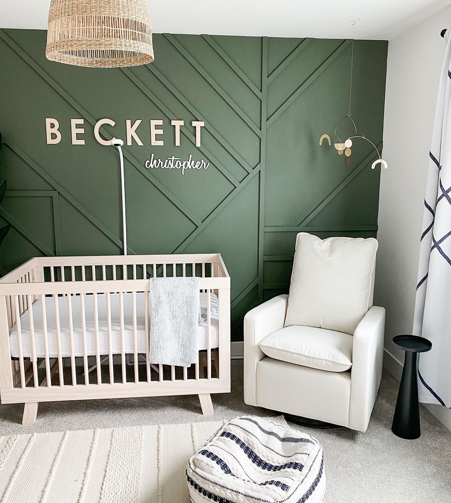 Contemporary and elegant green board and batten nursery featuring babyletto's Hudson Crib and Cali Glider