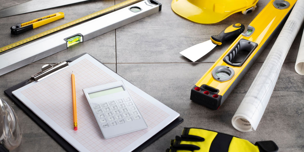 Image of various tools, blueprints, and a hard hat symbolizing contractor's work, representing an article titled 'Choosing a Small Renovation Contractor for Your Singapore Workspace