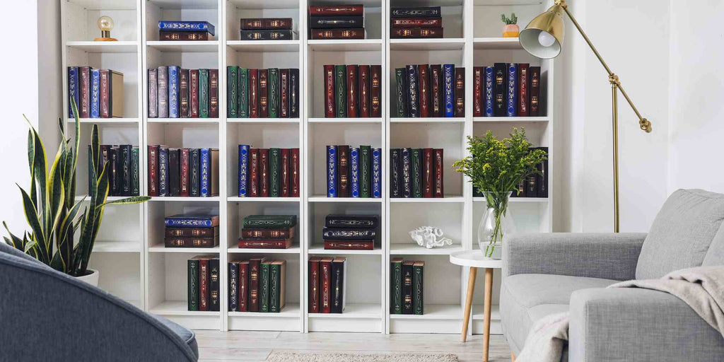 mage of tall bookshelves in a modern condo, exemplifying the strategy of maximising vertical space in zoning interior design. The bookshelves reach up towards the high ceiling, providing ample storage without taking up much floor space. This photo illustrates an effective way to optimise a condo's floor plan by utilizing vertical surfaces, demonstrating that every inch of a space can contribute to its functionality.