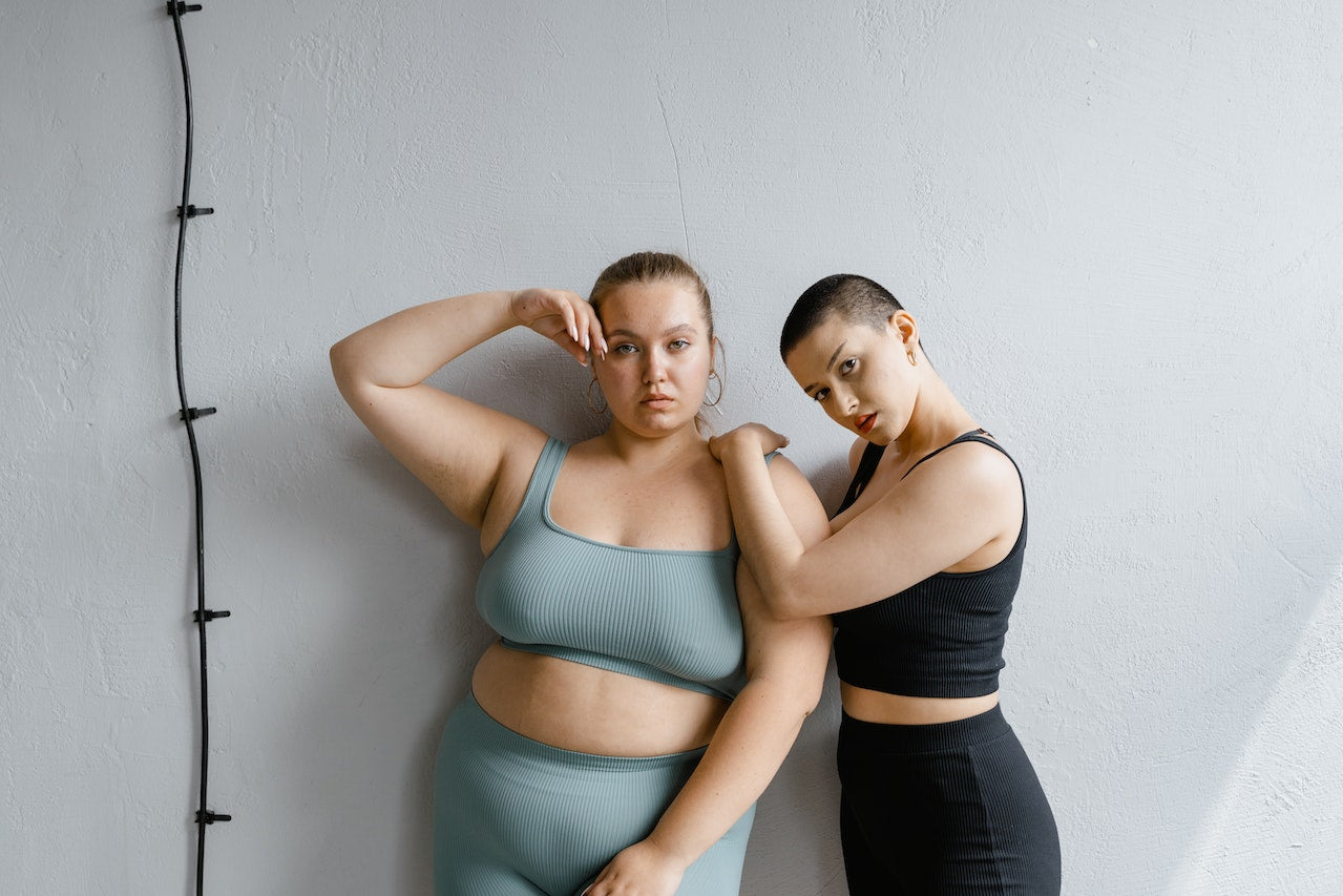 Two women posing in workout clothing