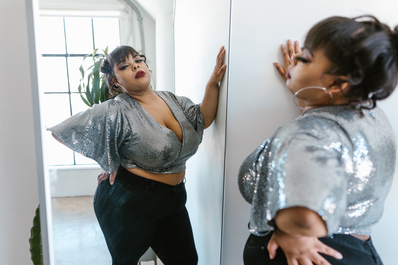 A confident plus-size woman in a sequined top