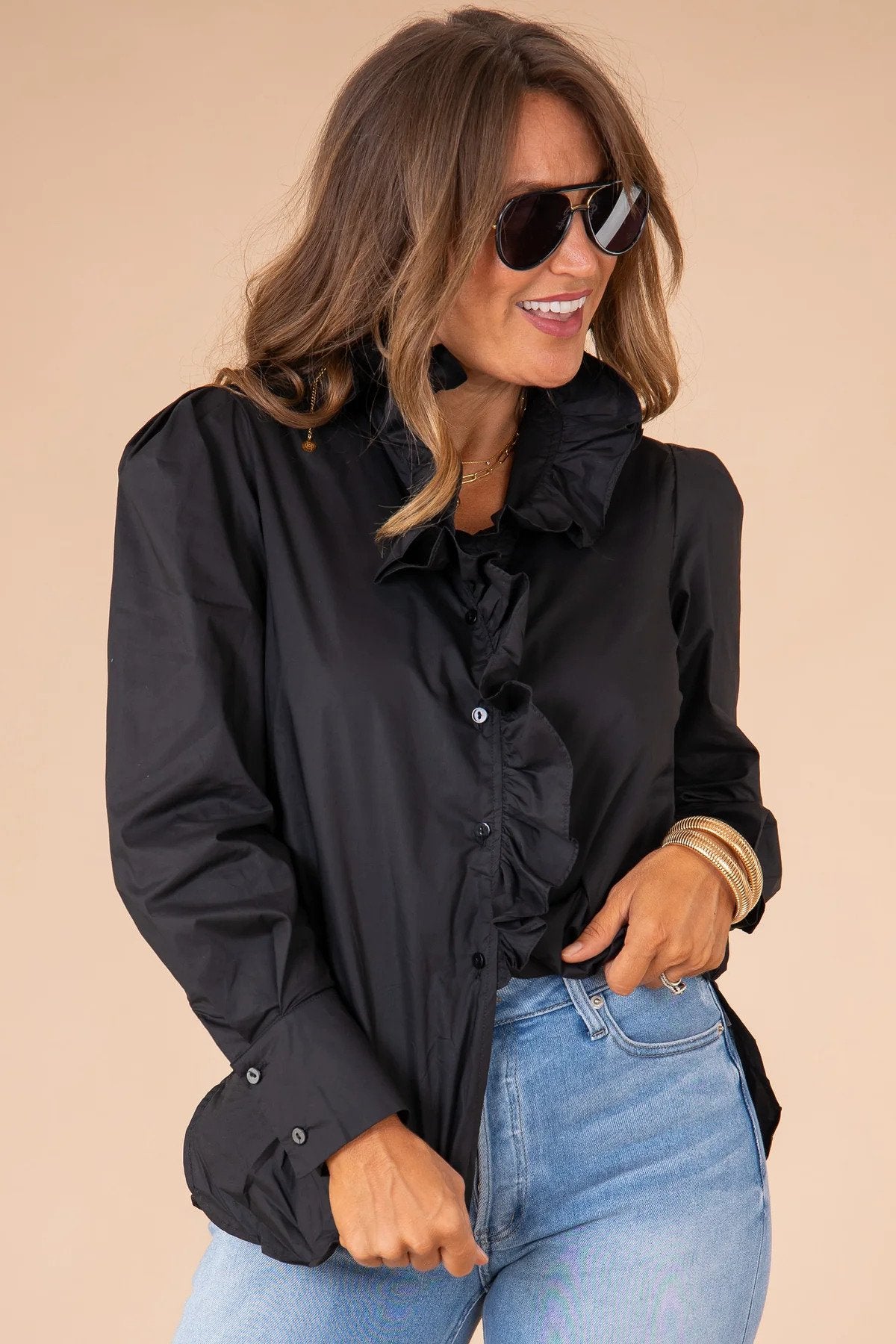 A woman wearing a black blouse with jeans