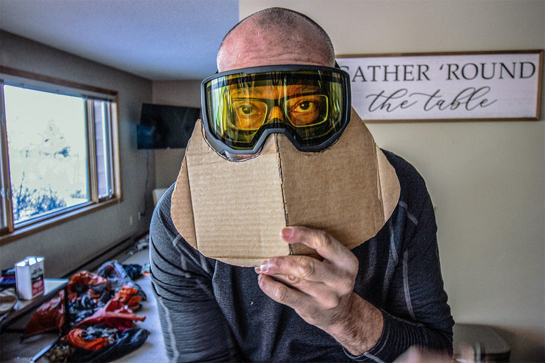 Product director with a cardboard cut out template of his Bird Beak inside, while wearing goggles and glasses.