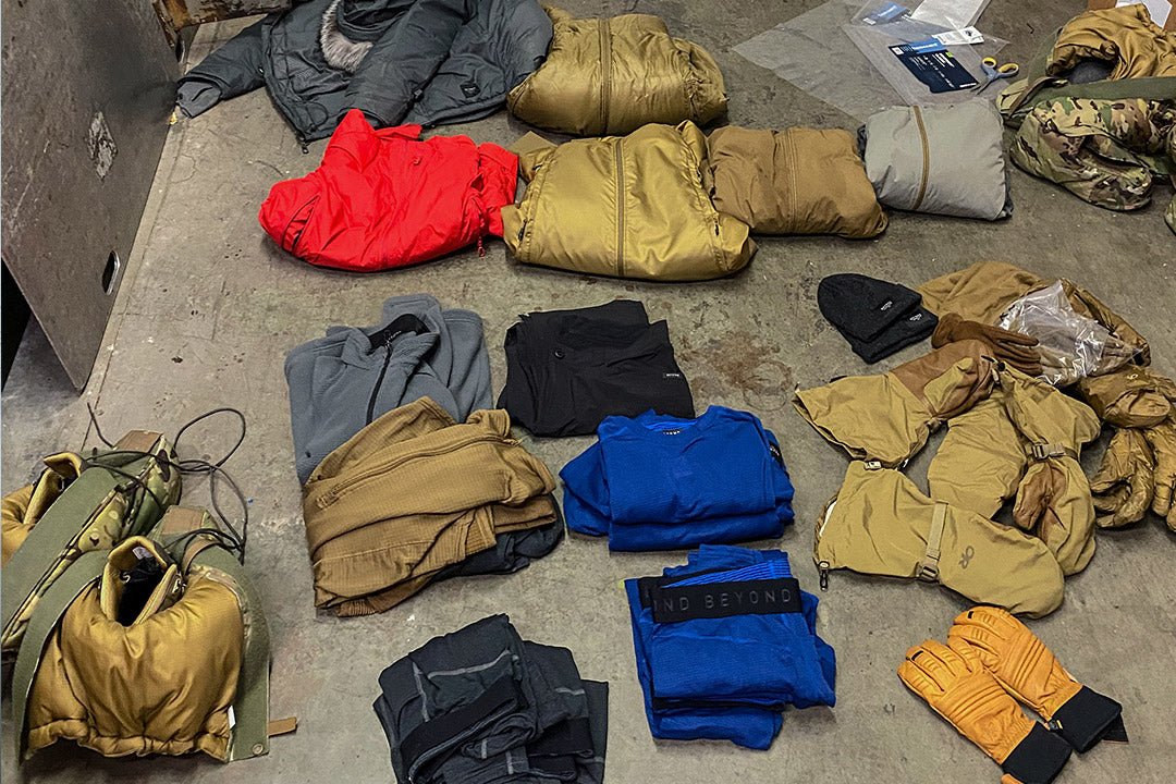 Sets of Beyond Clothing laid out on a warehouse floor in preparation for Arctic Simulation Trip