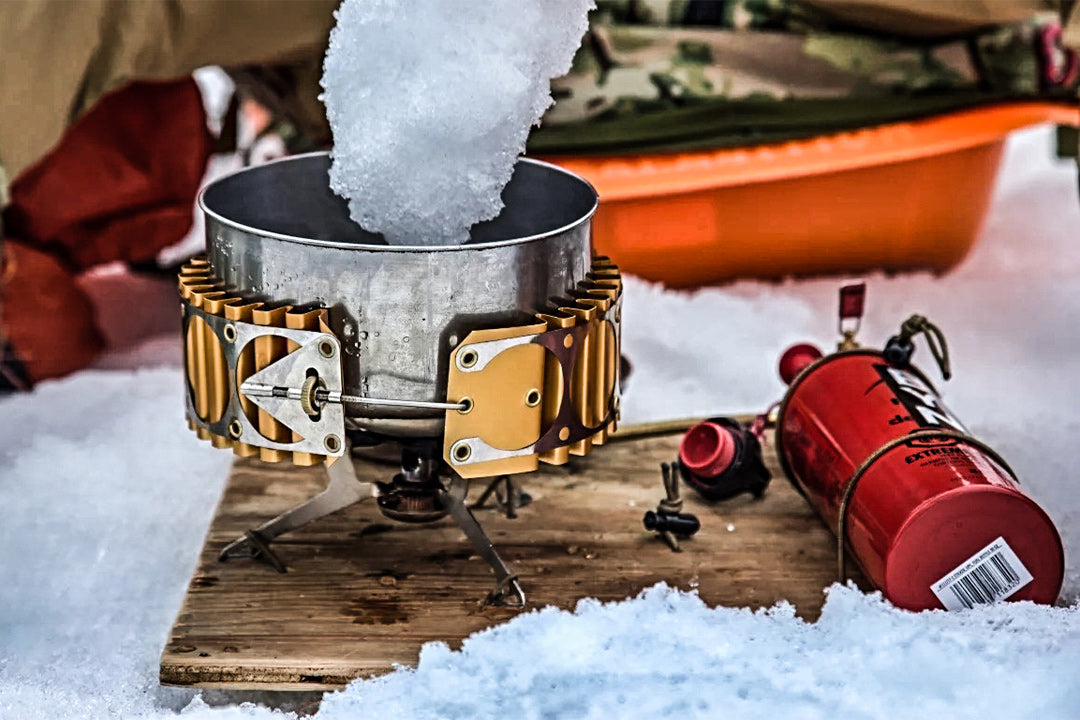 MSR Stove with modified base board melting snow next to a snow camp.