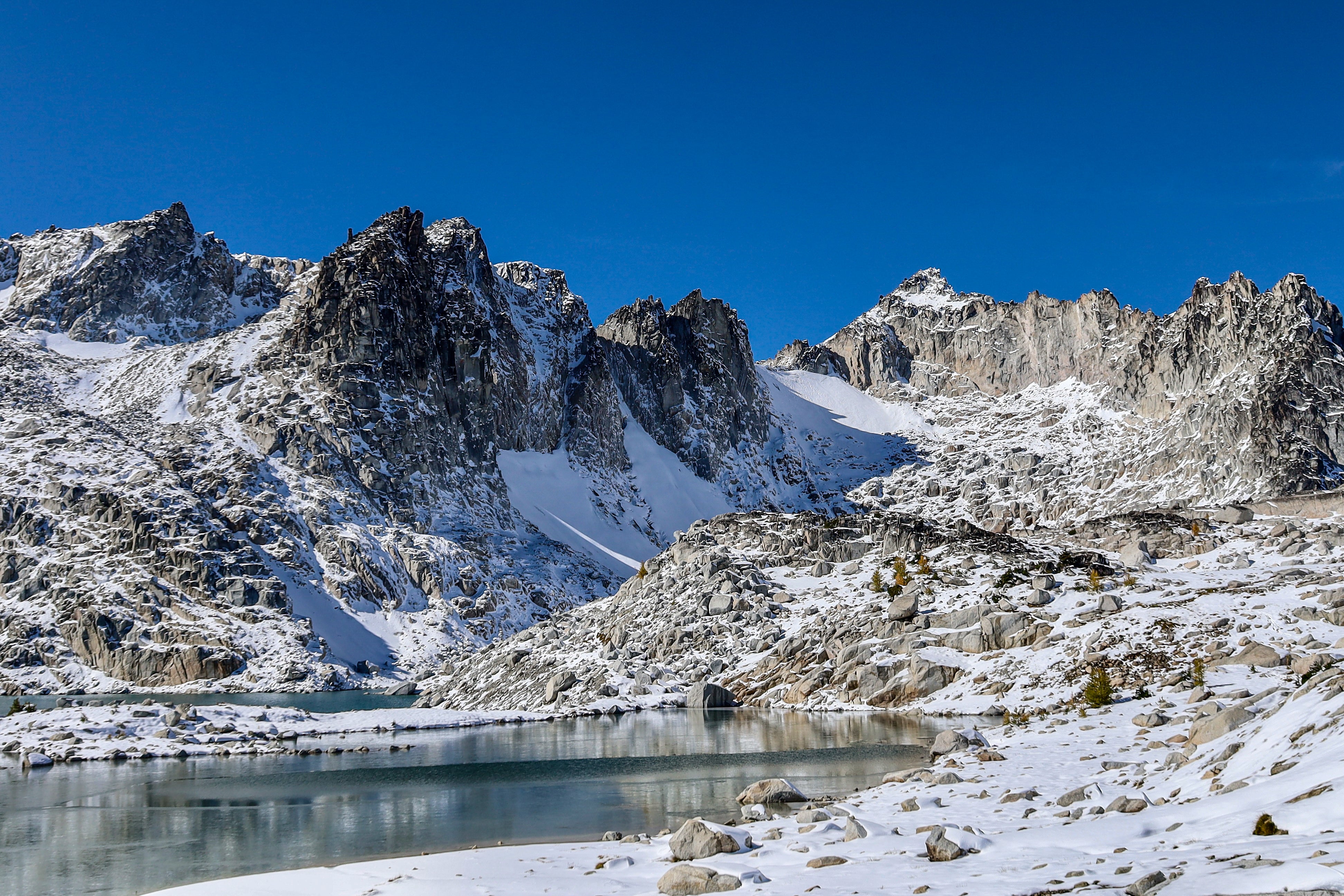 Landscape image taken while hiking of the Enchantments of a snowy mountain range with a lake.