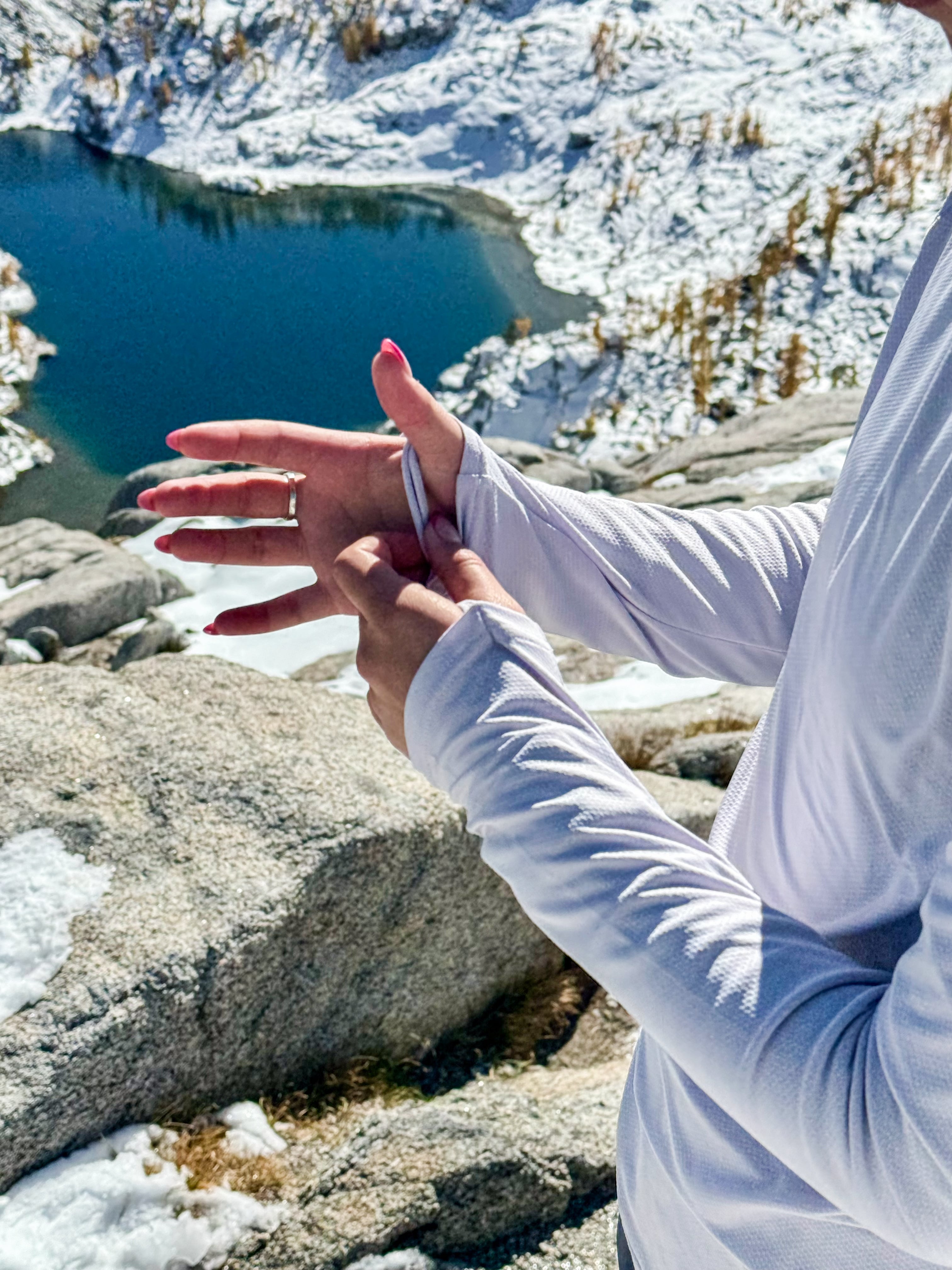 Hiker showing off the women's crew Geo-T while over looking a snow covered lake.