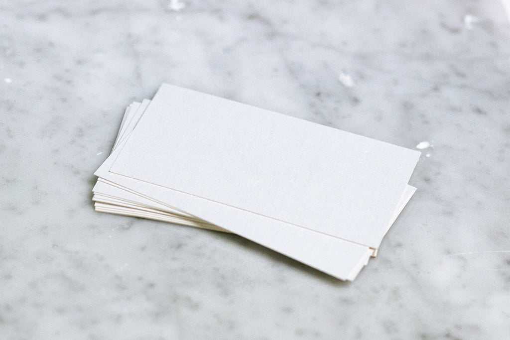 Pile of white cardstock paper on marble table