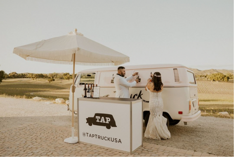 A pink Bev Bus with a Bride and Groom next to it.