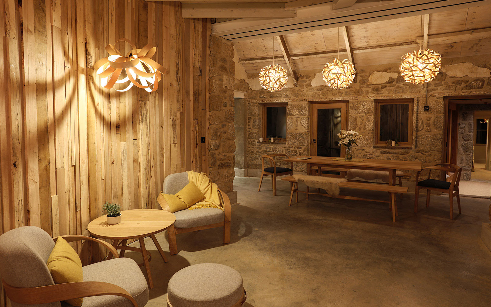 Inside Tom Raffield's house, with wooden walls, concrete floor and his steam-bent-wood lights