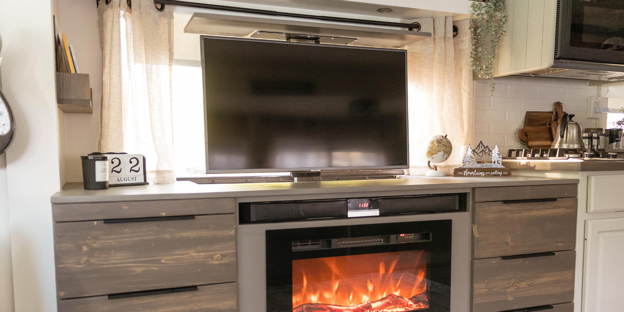Touchstone SRV PRO TV lift in RV motor home entertainment console with Touchstone Sideline 28 Electric Fireplace photo credit @rockinandrollinofficial