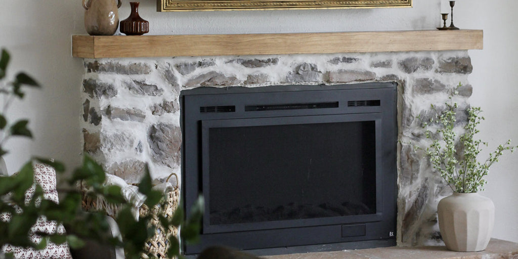 English cottage style stone fireplace by @shoemakesnew featuring a Touchstone Sideline Steel Forte electric fireplace.